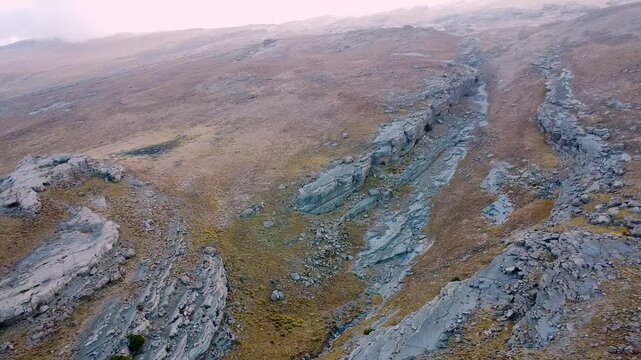 Drone flying over rocky dry Hojja Gur Gur Ota or Khodja Gur Gur Ota mountain range, Father of all caves, Boysuntau ridge, Surkhandarya region, Uzbekistan. Travel vacation expedition