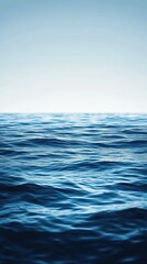 Obraz premium Calm ocean water with a clear, blue sky.
