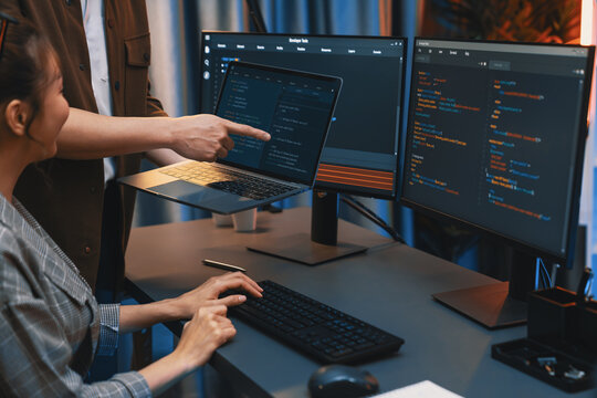 Serious of IT developers discussing intelligent website development coder system running data online two screens with laptop showing information network at neon light room at modern office. Infobahn.