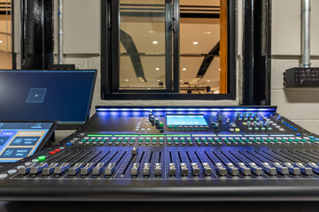 Mixing console, sound board, equipment in an auditorium, theater sound / projection booth.
