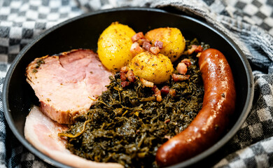 Norddeutsches Nationalgericht Grünkohl mit Schweinebacke Kohlwurst und Röstkartoffeln