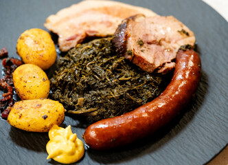 Norddeutsches Nationalgericht Grünkohl mit Schweinebacke Kohlwurst und Röstkartoffeln