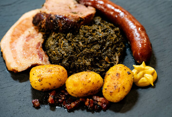 Norddeutsches Nationalgericht Grünkohl mit Schweinebacke Kohlwurst und Röstkartoffeln