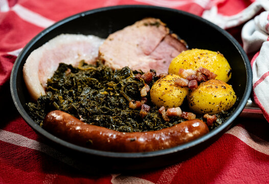 Norddeutsches Nationalgericht Gr&uuml;nkohl mit Schweinebacke Kohlwurst und R&ouml;stkartoffeln