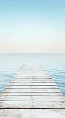 Fototapeta premium Beautiful wooden pier extending into calm blue ocean under clear sky