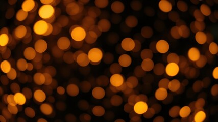Fototapeta premium A blurry background of out-of-focus warm-toned circles against a dark backdrop, creating an abstract and ethereal effect.