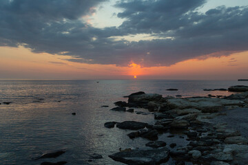 Rocky sea shore in rays of sunset sky. Caspian Sea Kazakhstan