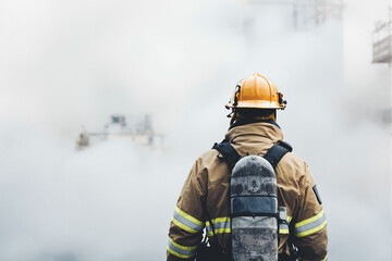 A firefighter monitors a smoke-filled area, preparing for action in a construction site emergency situation