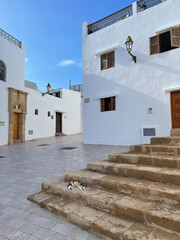 Moroccan views of white washed stone buildings against a blue sky decorated with wooden doors and windows