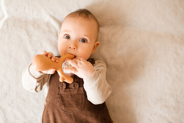 Cute baby boy 3-6 month old lying in bed close up with toy. Childhood.