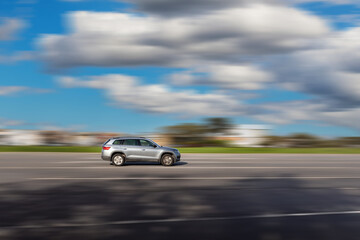 Dynamic running car on road. A gray SUV driving with a blurred background at speed