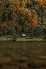 Unterkunft an einem Bergsee im Herbst, buntes Laub, Holzh&uuml;tte