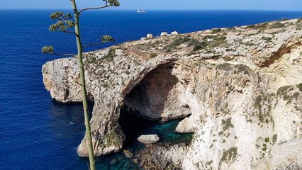 Cavern in the cliff called Blue Grotto. Delimara peninsula, near the village of Wied iż-Żurrieq, southeast coast of Malta, Europe.