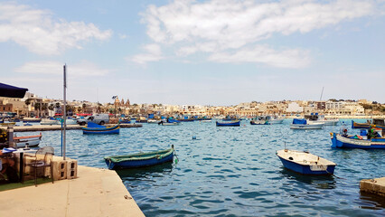 Promenade and harbor of the fishing village of Marsaxlokk, Peninsula of Delimara, island of Malta, Europe. 