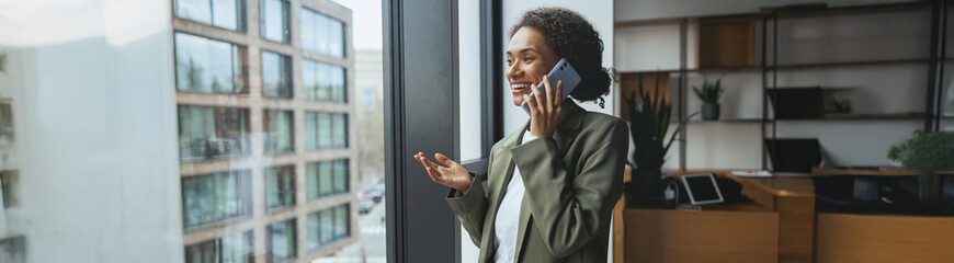 a woman is standing in front of a window talking on a cell phone