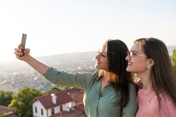 Two young women taking selfie together in the city
