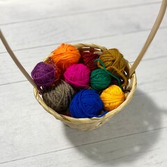 Many colorful multicolor wool balls in the basket on the table handmade craft hobby cozy photo 