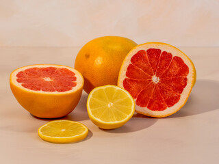 citrus fruits, grapefruit and lemon in a group cut in half, photo in front of warm background