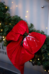 photo Festive holiday decoration featuring vibrant red velvet bow on evergreen Christmas wreath with twinkling lights enhancing seasonal ambiance and winter charm