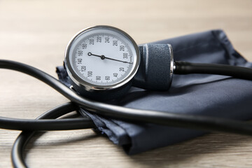 Blood pressure measuring device on wooden table, closeup