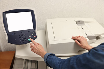 Woman using modern printer indoors, closeup. Printing house