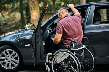 Man in Wheelchair Preparing to Transfer Into Car