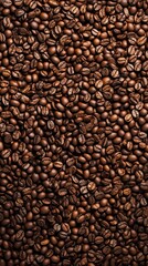 An overhead shot of a vast sea of coffee beans. The beans are a rich brown color, each with distinct texture, curves, and small imperfections.