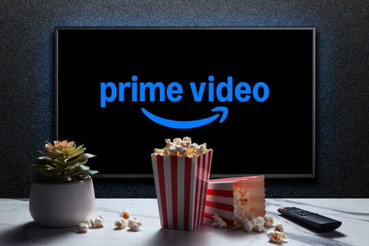 Amazon Prime Video logo on TV with popcorn boxes, remote control and home plant on the table. American subscription streaming media service. Astana, Kazakhstan - November 23, 2024.