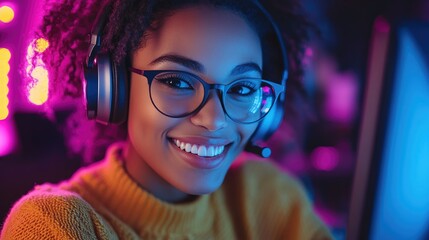 Smiling customer support representative wearing glasses and a headset, engaging with a computer in a vibrant, colorful call center environment.