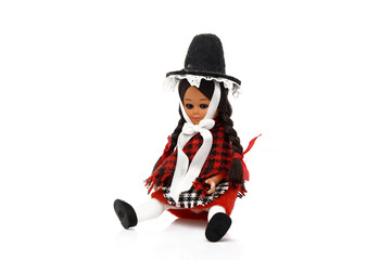 Traditional doll in vibrant attire sits gracefully on a white surface, showcasing cultural heritage...