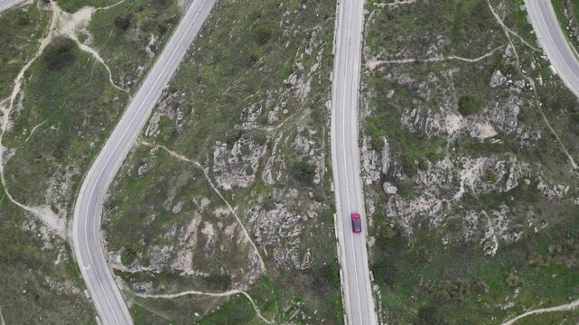 Aerial drone view of winding hairpin roads on the M-618 road towards Colmenar Viejo near Madrid, Spain offering stunning views of the surrounding countryside