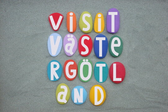 Visit Vastergotland, also known as West Gothland, non administrative province of Sweden, souvenir composed with multi colored hand painted stone letters over green sand