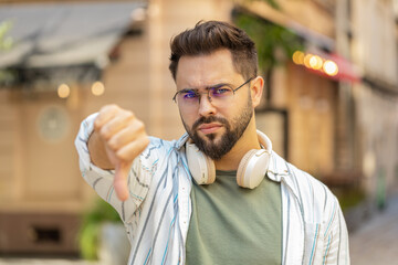 Dislike. Upset Caucasian young man showing thumbs down sign gesture, expressing discontent...