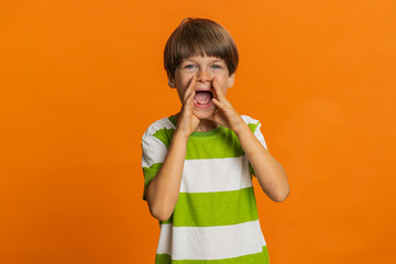 Young preteen child boy kid holding hands near mouth loudly screaming, shouting, yelling, announces...
