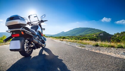 Obraz premium Motorcycle Parked on Road with Mountainous Background