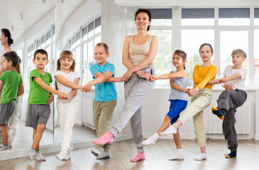 Boys and girls holding hands with woman coach and perform incendiary traditional Irish folk dance...
