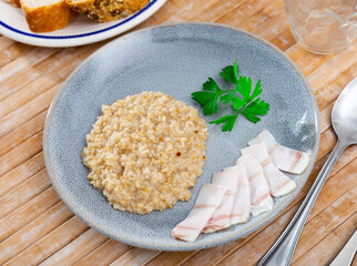 Appetizing lard with hot oatmeal and parsley. Hearty healthy dish