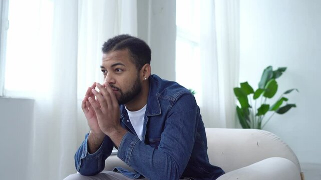 thoughtful african american man planning and thinking at home, guy came up with idea and solution to problem while sitting on chair