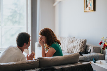 Two friends enjoy a lighthearted and fun moment together in a comfortable living room setting. Their joyful expressions highlight friendship and happiness.