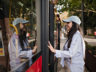 Young woman smiling getting in the bus on sunny urban street