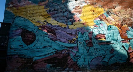 Fototapeta premium Vibrant street art mural on a brick wall with bold colors and abstract designs