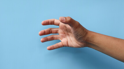man's hand hold, grab or catch some object, hand gesture. Isolated on blue background.