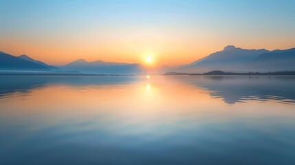 Fototapeta premium A tranquil landscape of a sunrise over a calm lake and mountains.