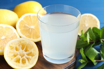Fototapeta premium Fresh juice in glass, lemons and mint on table, closeup