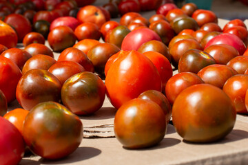 A top view of multiple vibrant ripe organic red cherry tomatoes in a large bowl.  All the ripe...