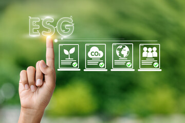 A hand is pointing to the letters ESG on a screen