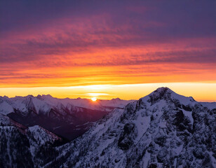 A breathtaking sunrise paints the sky with vibrant colors over a snow-capped mountain range