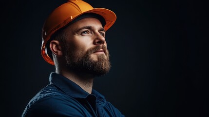 Confident Construction Worker in Safety Helmet Looking Upward with Determination and Professionalism in a Dark Studio Setting