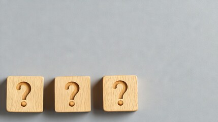 Exploring curiosity with wooden blocks displaying question marks on a minimalist gray background for innovative thinking