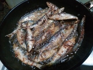 anchovies fried in Teflon on a dark background